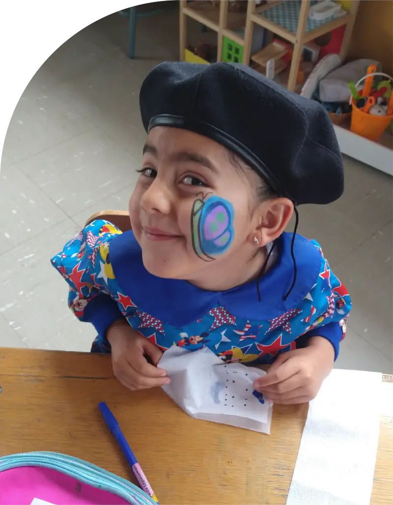 Foto de una niña de seis años, con la cara pintada. En dibujo es la mariposa de Morphy.