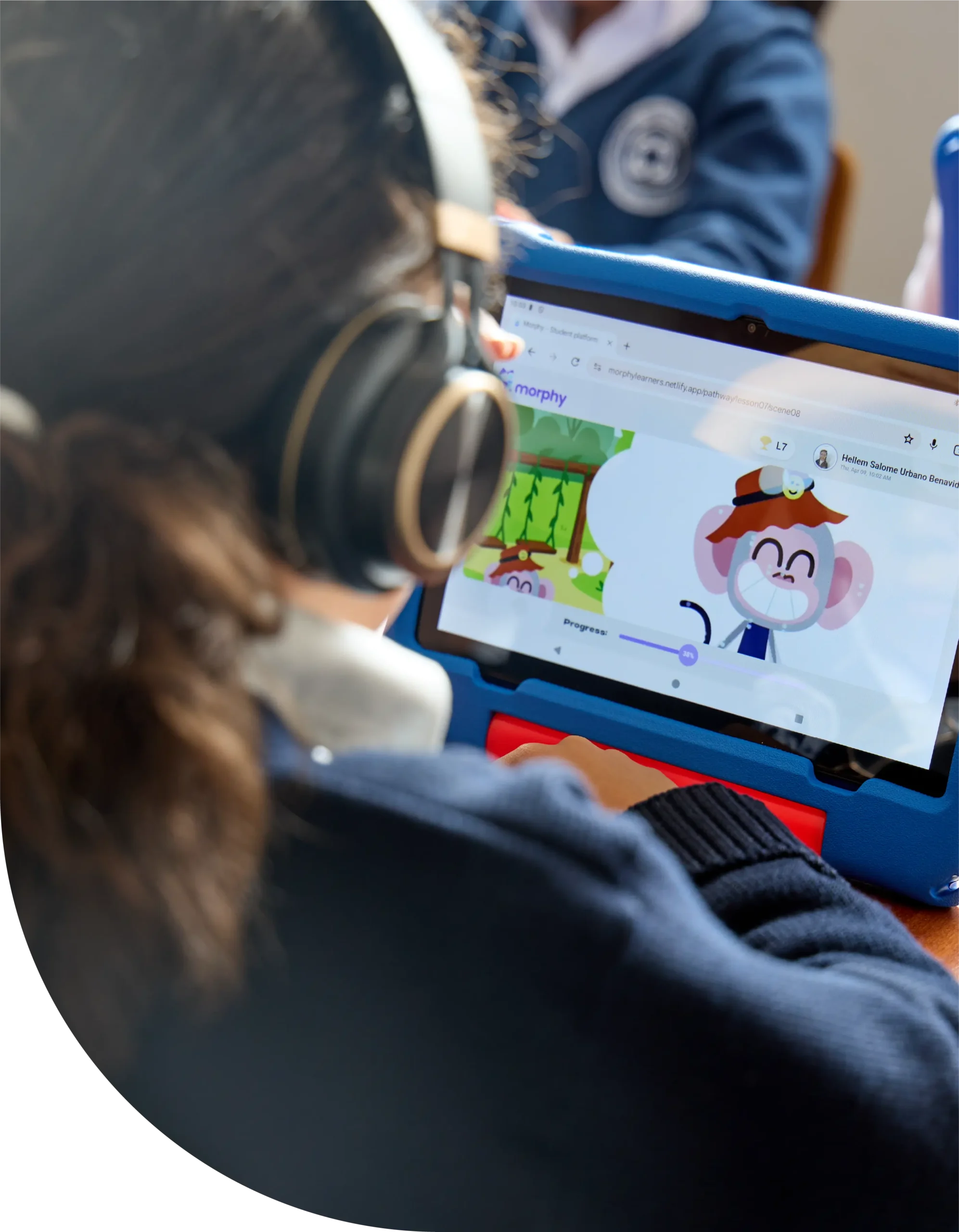 Niña de espaldas tomando una lección en Morphy. Se ve la pantalla de la tablet y el programa de ingles. 