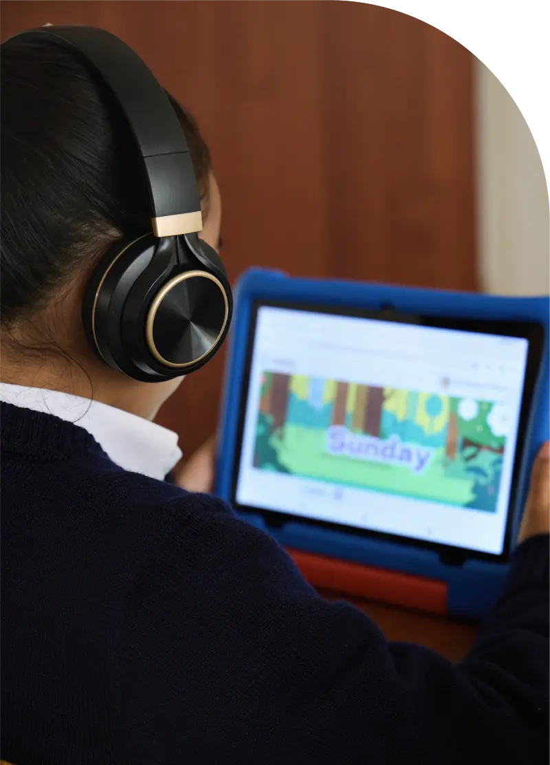 Foto de una niña de 5 años, de espaldas. Tomando una lección en Morphy en su Tablet.