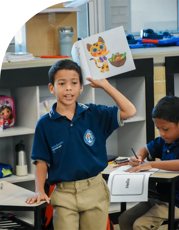 foto de niño de pie con un cuaderno en su mano derechoa mostrando un dibujo de Tala. Clase de ingles con Morphy