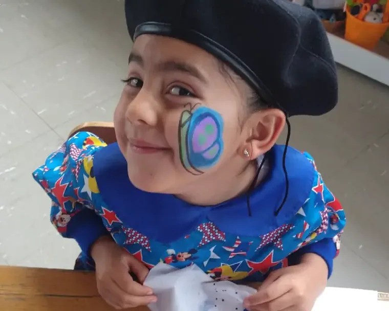 Niña disfrazada, con la cara pintada, sonriendo durante una clase de inglés con Morphy